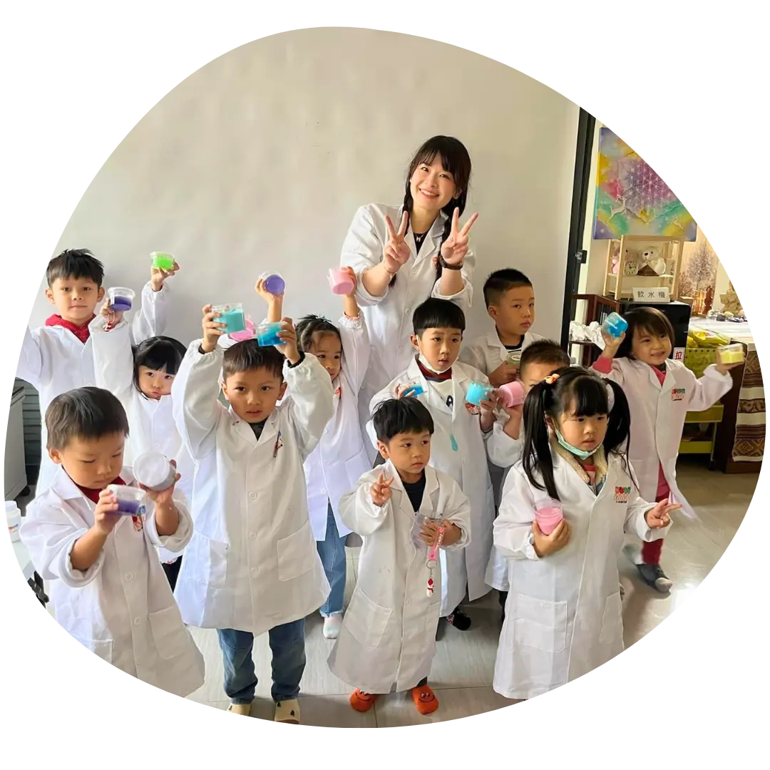 Vivi 老師與穿著實驗衣的孩子們在活動現場合照